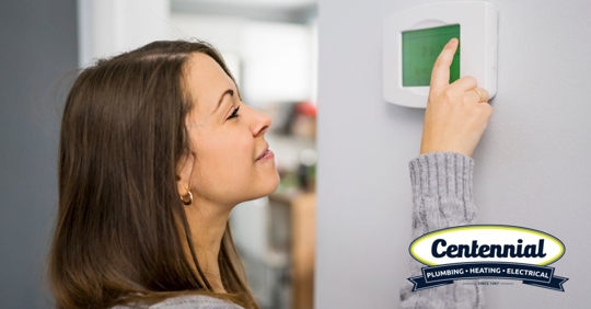 Woman Adjusting Thermostat